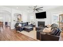 Spacious living room with a cozy fireplace, a ceiling fan, and comfortable leather seating, ideal for relaxation and entertainment at 2916 Cavalcade Cir, Johns Island, SC 29455