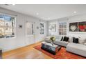Bright living room features hardwood floors, contemporary furnishings, and natural light from large windows at 301 Broad St # 1, Charleston, SC 29401