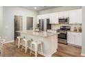 Modern kitchen boasts stainless steel appliances, a granite island, and white cabinetry at 313 Pine Crest View Dr, Summerville, SC 29486