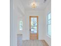 Bright foyer featuring a glass paneled door, white trim, and wood look flooring at 3285 Johnstowne St, Johns Island, SC 29455