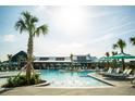 Resort-style pool area with lounge chairs, umbrellas, palm trees, and building on the edge of the pool at 339 Trailmore Ln, Summerville, SC 29486
