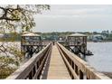 Scenic view of a wooden pier with gazebos, extending into the calm waters of a coastal community at 384 Blowing Fresh Dr, Charleston, SC 29492