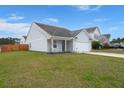 Inviting home with manicured lawn, front porch, and a convenient two-car garage at 420 Thoroughbred Dr, Moncks Corner, SC 29461