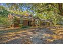 Charming brick home with mature trees, a private driveway and lush greenery all around the property at 562 Fort Johnson Rd, Charleston, SC 29412