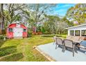 Spacious backyard patio area with an outdoor dining set and storage shed at 6019 Rembert Dr, Hanahan, SC 29410