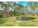 Lush backyard featuring mature trees, landscaping, and a tranquil swing set area at 6019 Rembert Dr, Hanahan, SC 29410