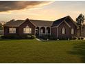 Charming brick home at sunset featuring a well-manicured lawn and inviting front porch at 760 Community Ave, Smoaks, SC 29481