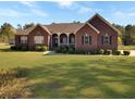 Charming brick home with a well-manicured lawn and inviting front porch at 760 Community Ave, Smoaks, SC 29481