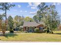Charming brick home with a well-manicured lawn and classic design with inviting curb appeal and mature trees at 107 Minus St, Saint George, SC 29477