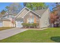 Home's exterior features a mix of siding, stone accents, and a well-maintained lawn at 108 Chemistry Cir, Ladson, SC 29456