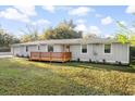 Charming single-story home with light gray siding, a front deck, and a manicured lawn with updated landscaping at 1174 Fort Johnson Rd, James Island, SC 29412