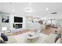 Bright open-concept living room with a fireplace, modern decor, and seamless transition to the kitchen and dining area at 1174 Fort Johnson Rd, James Island, SC 29412