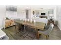 Dining room with modern decor features a wooden table, designer chairs and contemporary light fixture at 123 Royal Cainhoy Way, Huger, SC 29450