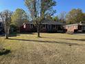 Charming brick home with a well-manicured lawn and mature tree providing ample shade at 1236 Fort Dr, Hanahan, SC 29410