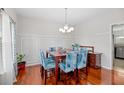 Bright dining room with hardwood floors features a chandelier, decorative chair coverings, and a plant at 184 Charlesfort Way, Moncks Corner, SC 29461
