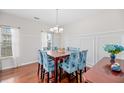 Elegant dining room boasts hardwood floors, large window, and a stylish chandelier at 184 Charlesfort Way, Moncks Corner, SC 29461