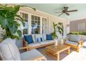 Comfortable seating on the porch with a blue ceiling, beautiful plants, and overhead fan at 184 Tradd St, Charleston, SC 29401
