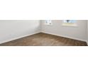 Bright bedroom featuring wood-look flooring, white walls, baseboards, and two windows at 2179 Macallan Blvd, Ravenel, SC 29470