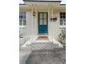 Inviting front entryway with a teal door, decorative columns, and a brick step at 223 Grove St, Charleston, SC 29403