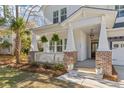 Charming front porch with brick accents and hanging plants, enhancing curb appeal at 233 Ashmont Dr, Wando, SC 29492