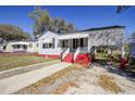 Quaint one-story house with a covered carport and a red-painted base, providing convenience and style at 2641 Woodlawn Ave, North Charleston, SC 29405