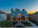 Stunning home with a welcoming front porch, warm interior lights, and professional landscaping at 2722 Crooked Stick Ln, Mount Pleasant, SC 29466