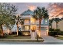 Charming two-story home at dusk, featuring a lovely porch, balcony, and a two car garage at 4108 Whiting St, Mount Pleasant, SC 29466