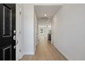 Bright hallway featuring wood-look floors, white walls, and access to living areas and kitchen at 418 Duskywing Dr, Goose Creek, SC 29445