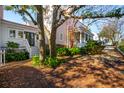 Home exterior featuring a covered porch and a yard with mature trees, offering curb appeal at 42 Sowell St, Mount Pleasant, SC 29464