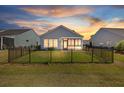 A fenced backyard with green grass and a covered patio, perfect for outdoor relaxation and entertainment at 422 Switchgrass Dr, Summerville, SC 29486