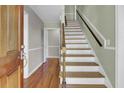 Entryway featuring hardwood floors and stairs with white risers and dark wood handrail at 649 Pawley Rd, Mount Pleasant, SC 29464