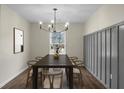 Elegant dining room with modern chandelier, wooden floors, and wainscoting at 7120 Sweetgrass Blvd, Hanahan, SC 29410