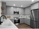 Modern kitchen with stainless steel appliances, grey cabinetry, quartz countertops and subway tile backsplash at 7120 Sweetgrass Blvd, Hanahan, SC 29410