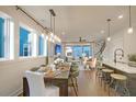 Open-concept dining area with a long wooden table, stylish chairs, and modern lighting at 717 Rumbling Leaf Ln, Summerville, SC 29486