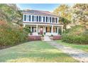 Inviting two-story home with a charming porch, brick foundation, well-manicured lawn, and lush greenery at 8115 Adams Run School Rd, Adams Run, SC 29426