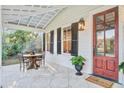 Cozy porch featuring an outdoor dining set, natural stone flooring, and a stylish wood door at 8115 Adams Run School Rd, Adams Run, SC 29426