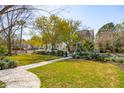 Expansive front yard with lush lawn, mature trees, and sidewalk leading to residences at 873 Tupelo Bay Dr, Mount Pleasant, SC 29464