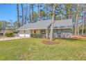 Single-story home with lush front lawn, mature trees, a two-car garage, and inviting curb appeal at 891 Wynford Ct, Mount Pleasant, SC 29464