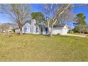 Beautifully landscaped front yard and classic painted brick home with attached garage at 9861 Levenshall Dr, Ladson, SC 29456