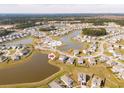 Aerial view of community with lakes, pool, and homes surrounded by trees at 109 Airy Dr, Summerville, SC 29486