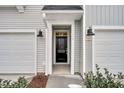 Close-up of the front door entrance, flanked by coach lights and a 1-car garage at 110 Brown Swiss Cir, Summerville, SC 29483
