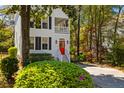 Beautiful two-story home featuring a porch, red front door, and a well manicured lawn at 1100 Sea Island Crossing Ln, Mount Pleasant, SC 29464