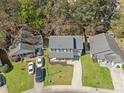 Aerial view of the home with its covered porch, garage, long driveway and green surroundings at 115 Trickle Dr, Summerville, SC 29483