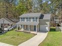 Attractive two-story home featuring a covered front porch, attached garage, and manicured lawn at 115 Trickle Dr, Summerville, SC 29483