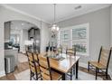 The open dining room features hardwood floors, an elegant chandelier, and ample natural light at 1173 Triple Crown Court, Mount Pleasant, SC 29429