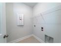 Bright laundry area with tile floors, upper shelving, and utility connections at 125 Royal Cainhoy Way, Huger, SC 29450