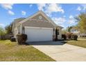 Lovely home with a two-car garage, mature landscaping, and a well-kept front lawn at 1309 Basketweaver Way, Hanahan, SC 29410