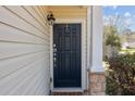 Close-up of a home's front entry featuring a stylish black door, stone accents, and a welcoming exterior light at 1309 Basketweaver Way, Hanahan, SC 29410