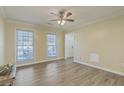 Bright living room with laminate floors, a ceiling fan, and large windows for natural light at 131 Kennington Dr, Goose Creek, SC 29445