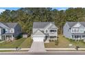 Aerial view of a two-story home with porch and balcony, nestled between two similar homes at 165 Vango Dr, Goose Creek, SC 29445